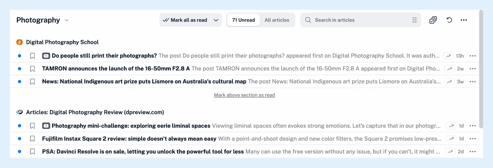 Uma pasta do Inoreader agrupada por feed, com um título com o nome do feed acima dos artigos de cada feed e um link Marcar seção acima como lida entre os grupos.